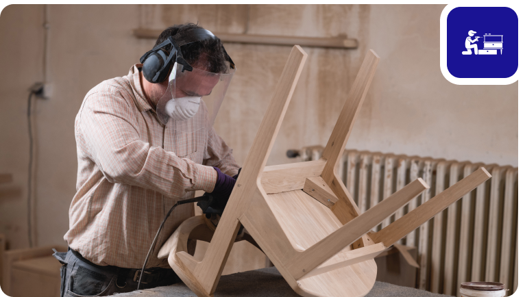 Group 1321315772 Woodworker sanding an upside-down wooden chair.