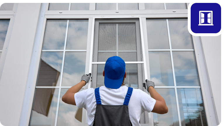 Group 1321315776 Worker installing a window screen, blue cap.